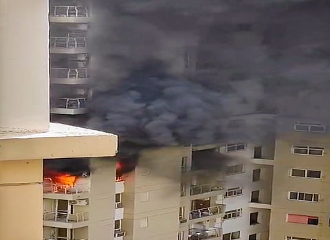 Smoke billows out after a fire broke out in the Lotus Boulevard Society at Sector 100 in Noida, Thursday.