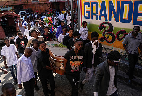 Friends and family accompany the coffin that contain the remains of Jhon-Roselet Joseph, killed by a stray bullet during clashes between police, and gang members.