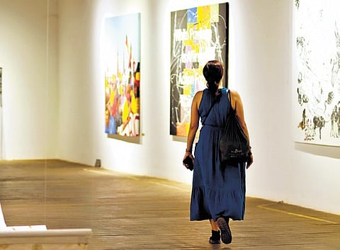 A woman looking at the artworks displayed at Kochi-Muziris Biennale (KMB)