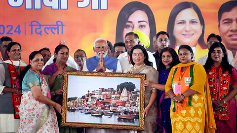 PM Modi being presented a memento during a public meeting in support of BJP candidates, at Dwarka, on Wednesday.