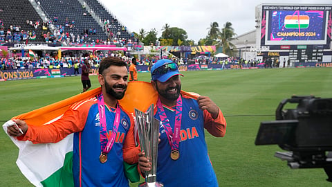 India's Virat Kohli, left, and captain Rohit Sharma pose with the winners trophy after defeating South Africa in the ICC Men's T20 World Cup final cricket match at Kensington Oval in Bridgetown, Barbados, Saturday, June 29, 2024.