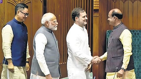 The Leader of Opposition (LoP) Rahul Gandhi shaking hands with Speaker Om Birla, as Prime Minister Narendra Modi and Parliamentary Affairs Minister Kiren Rijiju stand behind him.