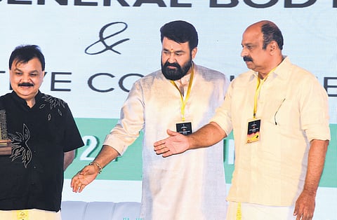 AMMA president Mohanlal guides Siddique, the new general secretary, to the chair at the annual general body meeting of the association in Kochi on Sunday. Outgoing general secretary Edavela Babu is also seen