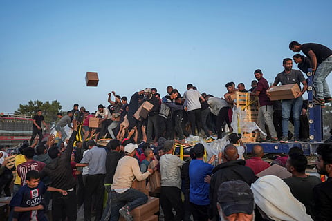 Palestinians are storming trucks loaded with humanitarian aid brought in through a new U.S.-built pier, in the central Gaza Strip, Saturday, May 18, 2024.