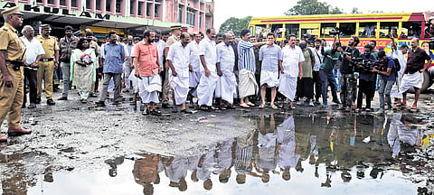 Transport Minister K B Ganesh Kumar and other officials inspect a waterlogged area at the KSRTC bus stand on Saturday