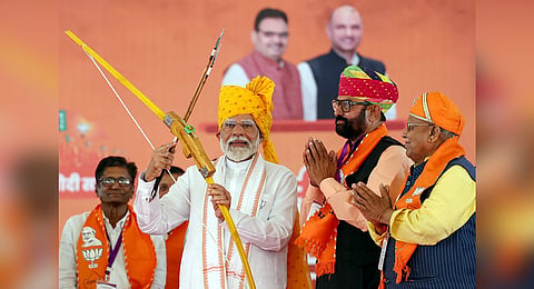Taking aim: PM Modi with a bow and arrow at the now-famous Banaswara rally.