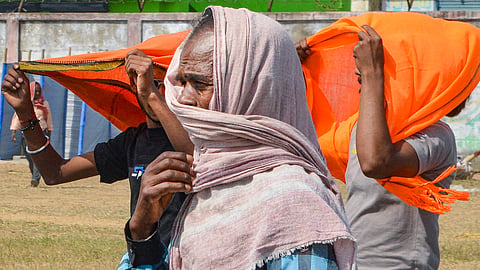 People cover their heads with scarves to protect them from the scorching heat on a hot summer day in Patna, Friday, May 31, 2024.