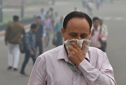 A pedestrian covers his face with a handkerchief for protection against air pollution in New Delhi.