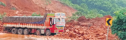 A lorry amid the rubble near the hillock that slid on the highway near Belase village at Shirur, on Wednesday