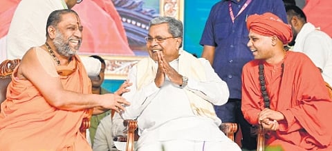 Chief Minister Siddaramaiah shares a light moment with Subudhayantra Swamiji of Sri Raghavendra Math and Immadi Siddarameshwara Swamiji of Bhovi Gurupeet in Chitradurga on Saturday
