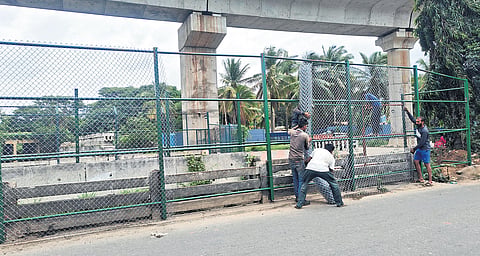 Workers install an iron mesh around the stormwater drain
near Jnanabharati Junction on Sunday