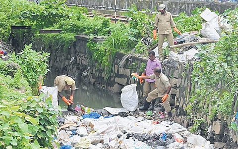 Corporation workers on Tuesday remove garbage from the area where the body of sanitation worker Joy was found in the Amayizhanchan canal on the Thakaraparambu stretch