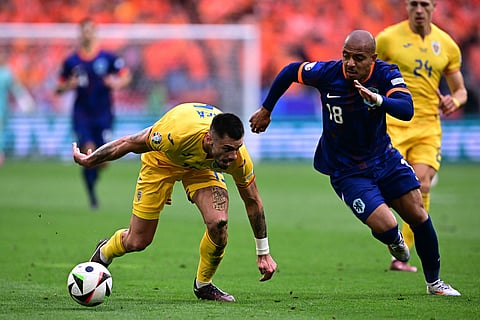 Romania's forward Denis Dragus (L) and Netherlands' forward Donyell Malen fight for the ball during the UEFA Euro 2024 round of 16 football match between Romania and the Netherlands on July 2, 2024.