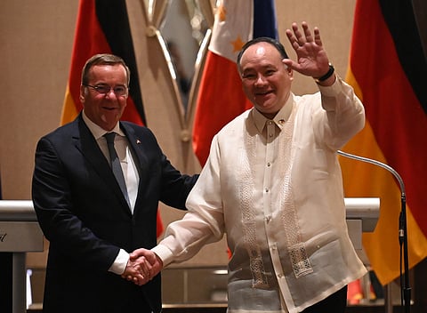 Philippine Defense Secretary Gilberto Teodoro (R) shakes hands with German Defence Minister Boris Pistorius after their joint press conference at a hotel in Manila