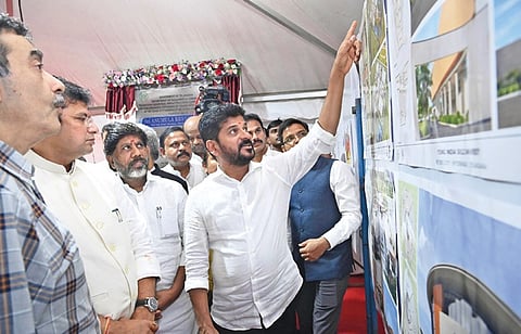 Chief Minister A Revanth Reddy goes through plans for the Young India Skills University after laying the foundation stone for it at Mirkhanpet of Kandukur mandal in Rangareddy district on Thursday