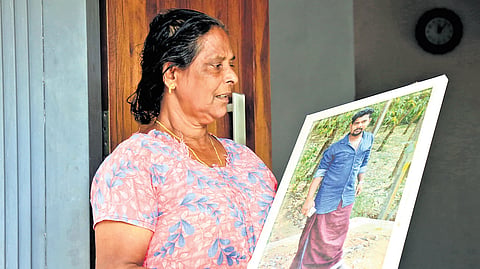Usha, a survivor, shows the photo of her son Vinoy who died in
the landslide at Kavalappara