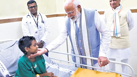 Prime Minister Narendra Modi pampering a landslide victim at Wims Hospital in Meppadi on Saturday