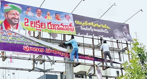 BRS activists tear down a flexi put up by Congress supporters demanding the resignation of T Harish Rao and another with the CM’s picture in Siddipet on Saturday