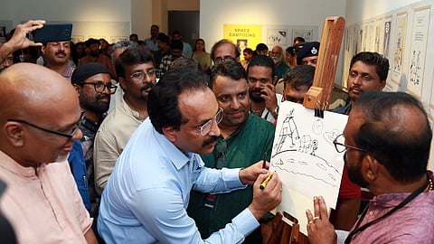 ISRO Chairman Dr S Somanath inaugurates Kerala Cartoon Academy's cartoon exhibition 'Caritoon' by drawing a cartoon
at the Ernakulam Durbar Hall Art Gallery.