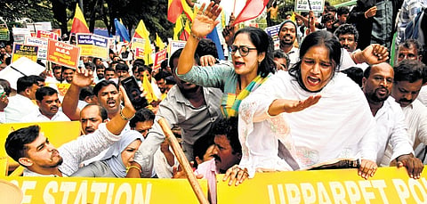 Members of various organisations and Congress supporters carry placards and raise slogans as part of ‘Raj Bhavan Chalo’, in protest against Governor Thaawarchand Gehlot over his sanction of prosecution of Chief Minister Siddaramaiah, at Freedom Park in Bengaluru on Tuesday