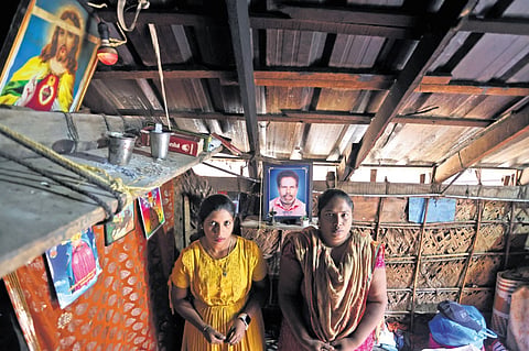Divya Mol and Vini V in their home near the photo of their father Victor Thomas, who lost his life in a boat accident at Muthalapozhi three months ago