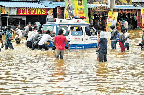 Residents of Singh Nagar help an ambulance stuck in floodwater.