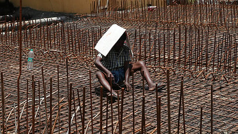 Even as the rain takes a brief interlude, the Sun makes known its presence on Tuesday forcing a construction worker covers himself with cardboard sheet to escape from heat in Puducherry