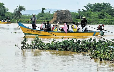 Residents of Jakkulanakkalam village use boats to reach safer locations as the main road leading to their village was cut off following the flood