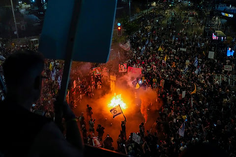 A demonstrator waves the Israeli and U.S. flags during a protest against Prime Minister Benjamin Netanyahu's government and call for the release of hostages held in the Gaza Strip by the Hamas militant group.