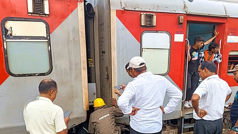 Railways officials inspect the Magadh Express train after its coupling broke, splitting the train into two parts, near Tudiganj station, in Buxar district, Sunday, Sept. 8, 2024.