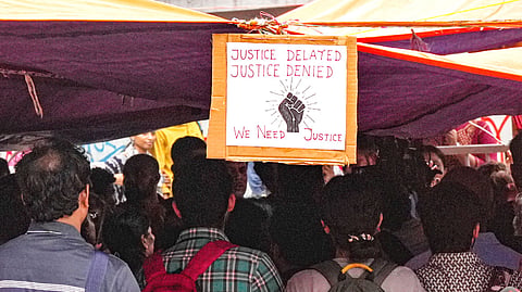 FILE - A poster hangs at the protest site as junior doctors continued their 'cease work' and sit-in demonstration against the RG Kar Hospital incident for the third consecutive day, outside Swasthya Bhavan in Kolkata,