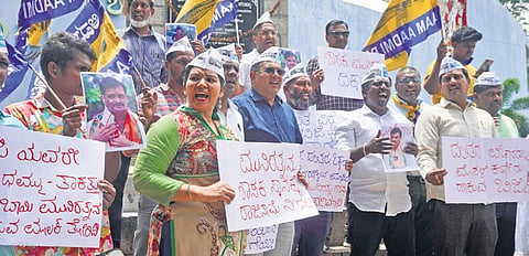 Aam Aadmi Party members protest against BJP MLA Munirathna at Freedom Park in Bengaluru on Monday