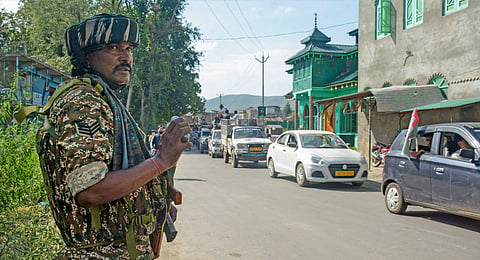 A security personnel stands guard during a roadshow of MP and Awami Ittehad Party chief Sheikh Abdul Rashid in support of party candidate from Tral constituency Harbaksh Singh ahead of J&K Assembly elections, at Tral area in Pulwama district, Jammu & Kashmir, Sunday, Sept. 15, 2024.