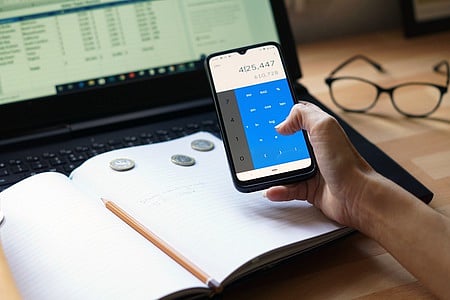A closeup shot of an entrepreneur working from home on his personal finances and savings.