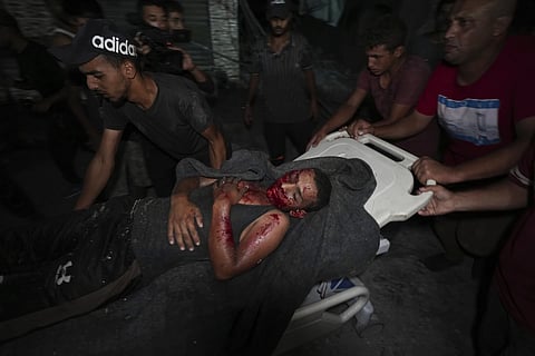 Palestinians carry an injured man from a destroyed mosque following an Israeli airstrike in Deir al-Balah, Sunday, Oct 6, 2024.