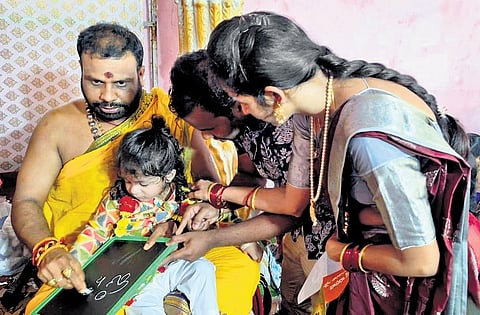 A priest oversees the Akshara Abhayasam ritual at the Gnana Saraswati temple in Basara, Nirmal district, on Wednesday
