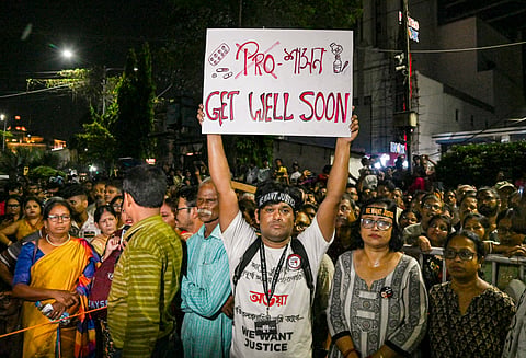 A man holds a placard during a 'mass convention' called by junior doctors near the hunger strike site, protesting against the alleged rape and murder of a trainee doctor, in Kolkata, Friday, Oct. 11, 2024.