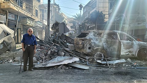 A man walks past the rubble of a shop after an Israeli airstrike targeted the marketplace in the southern Lebanon