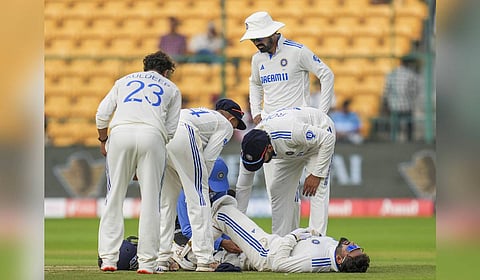 India's wicket-keeper Rishabh Pant being attended by a team official after an injury on the second day of the first test match between India and New Zealand in Bengaluru.