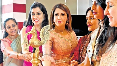 Veena Jain (centre) lights the lamp at a jewellery exhibition.
