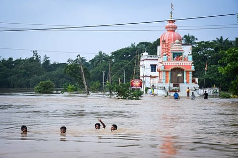File | Kids swim in the flood water at Baincha Village under Balasore Sadar block after the village marooned due to swelling Budhabalanga river in Balasore district