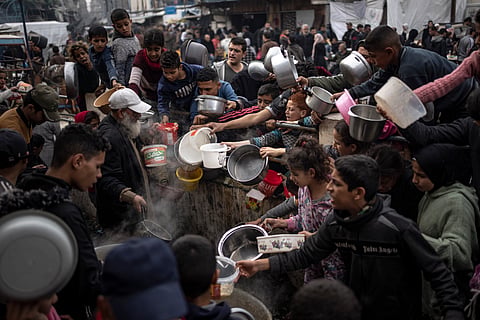 Palestinians line up for a meal in Rafah, Gaza Strip, Thursday, Dec. 21, 2023.