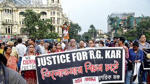 People holding banners take part in a protest against the RG Kar Hospital rape and murder case in Kolkata.