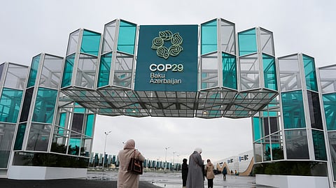 People enter the venue of the COP29 UN Climate Summit, in Baku, Azerbaijan.