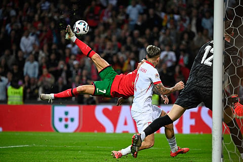 Portugal's forward Cristiano Ronaldo (L) scores their fifth goal during the UEFA Nations League, League A, Group 1 football match between Portugal and Poland at the Dragao stadium in Porto, on November 15, 2024.