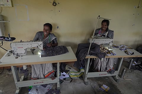 H. Gauri, 32, right, and S. Jayalakahmi laugh as they use electric sewing machines to stitch clothes in a small garage, at the campus of the Swami Vivekananda Youth Movement, a nonprofit that works to help poor and Indigenous communities, in Kenchanahalli, India, Monday, Sept. 23, 2024.