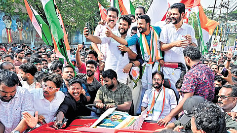 Vadakara MP Shafi Parambil taking a selfie with Rahul Mamkootathil and fellow UDF leaders during the victory rally taken out in Palakkad after the bypoll win on Saturday