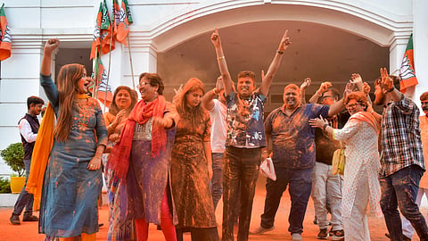 BJP workers celebrate NDA's victory in Assam by-elections, at the party office, in Guwahati on Saturday.