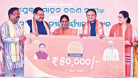 CM Majhi and others handing over a cheque to a Subhadra beneficiary