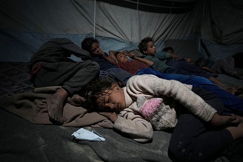 Shireen Daifallah's children, who were displaced from northern Gaza, sleep in their tent at a camp for displaced people in Deir al-Balah.